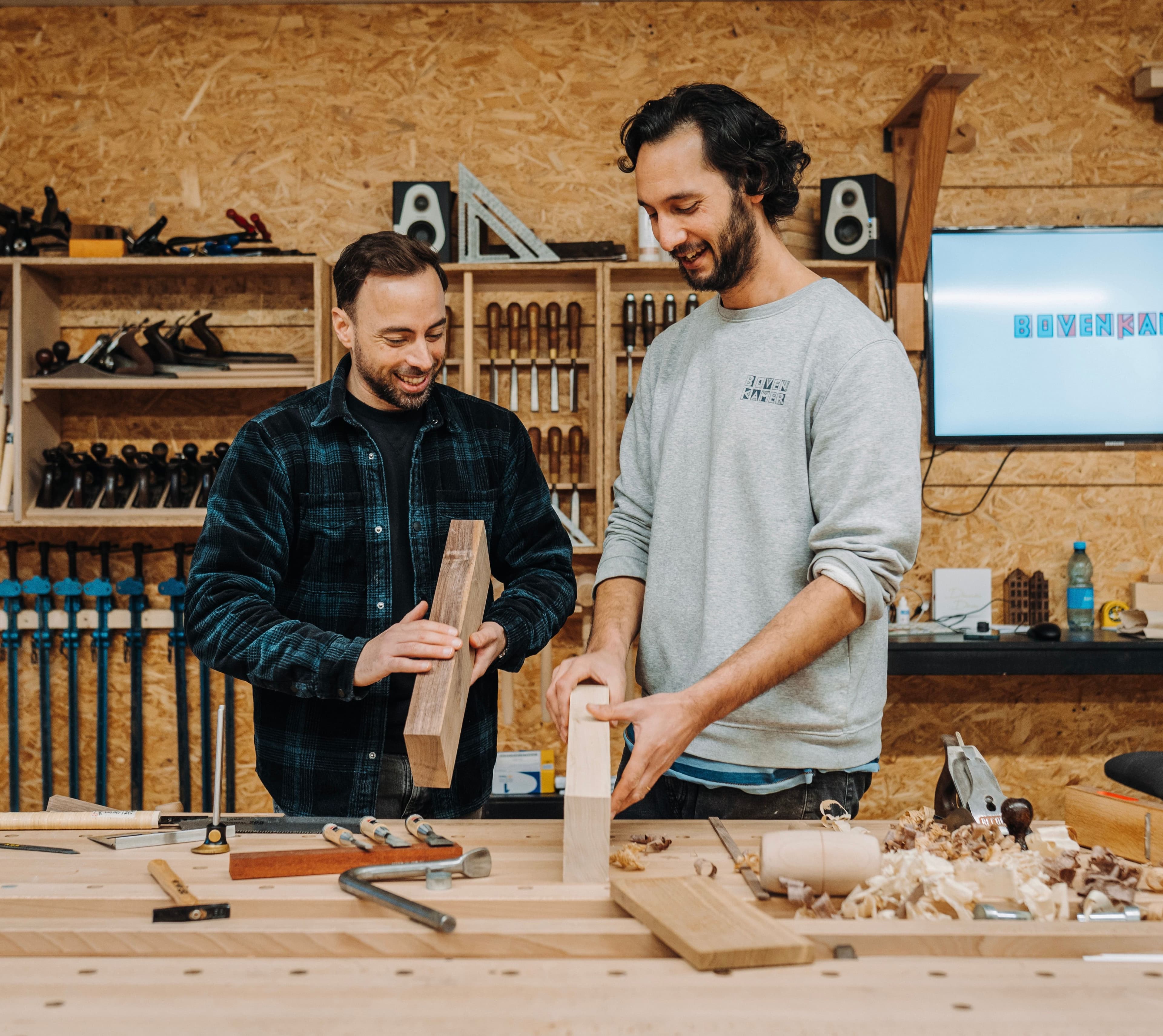 Edwin en Jochem werken aan een houten meubel in de houtwerkplaats in Utrecht
